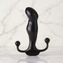 Zwarte glanzende prostaat massager met perineum-armen op marmeren achtergrond